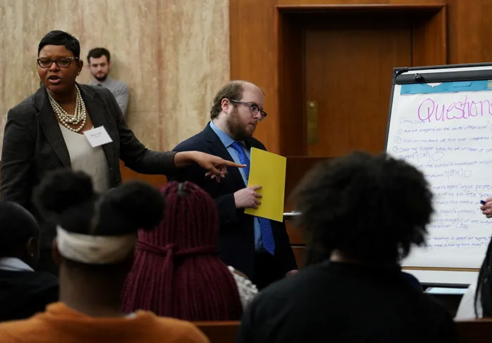 Attorneys working with students in a courtroom simulation at the federal courthouse in DC.